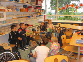 Kinder der 2. Klasse lesen den Kindergartenkindern vor.